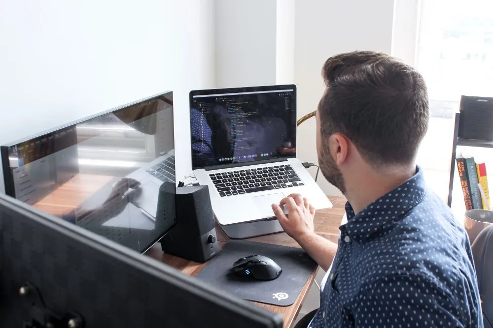 Man at desk on multiple monitors